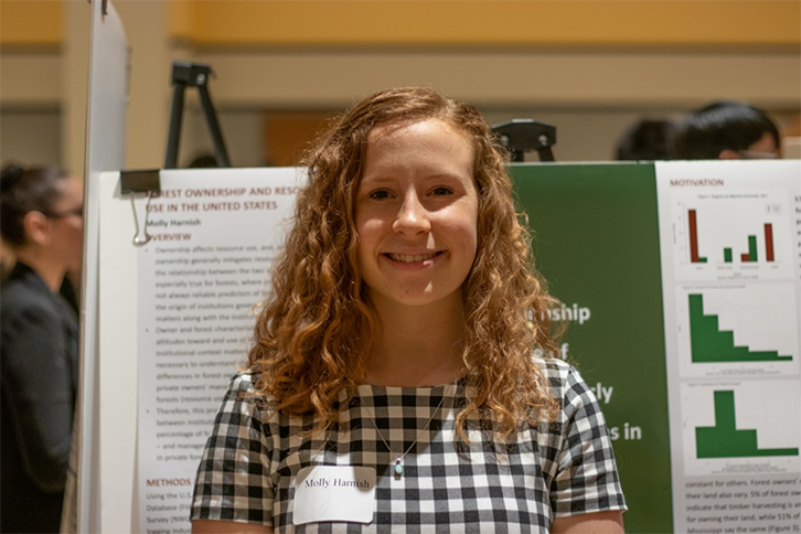Molly Harnish stands in front of a research poster